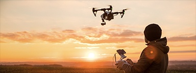 a man operating a drone with remote control at sunset