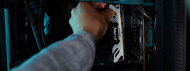 Osoba montująca moduł pamięci Kingston FURY Renegade DDR5 w czarnej obudowie komputera.