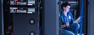 Ingeniera de red en un bastidor de servidores con un cable de Ethernet