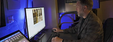 O Projecionista digital, Ryan Carpenter, sentado em um monitor de computador.