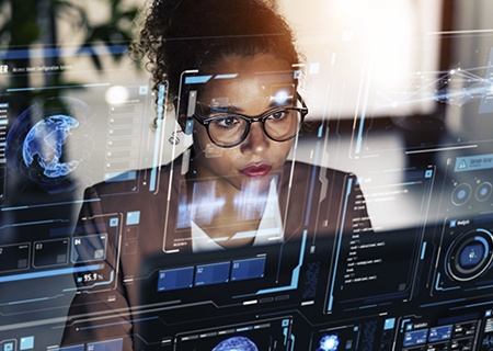 Una mujer trabajando en una oficina con una visualización frontal delante de ella