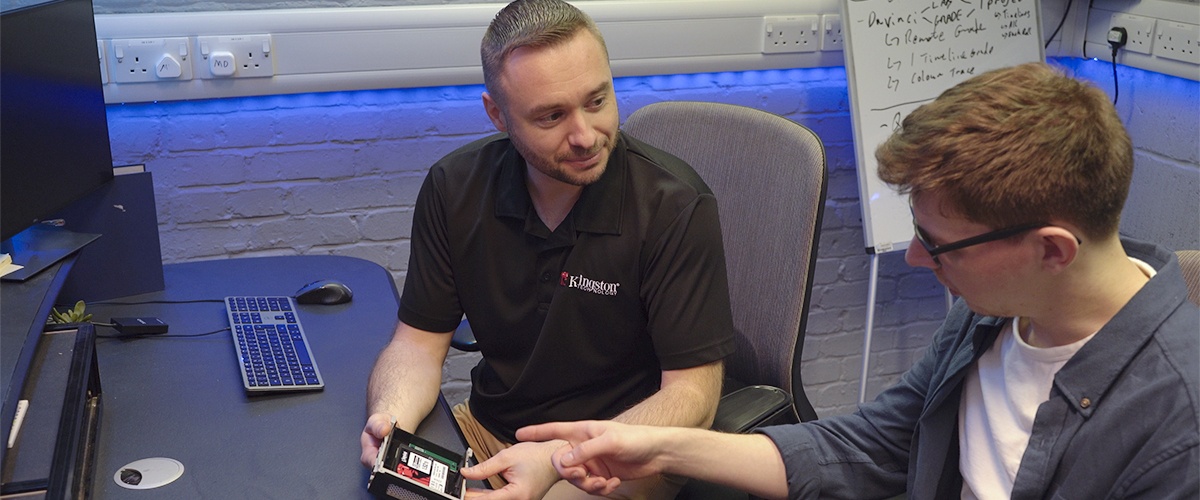 Geoffrey, Jake ile yükseltme seçeneklerini tartışırken elinde Kingston DC600M SSD'yi tutuyor