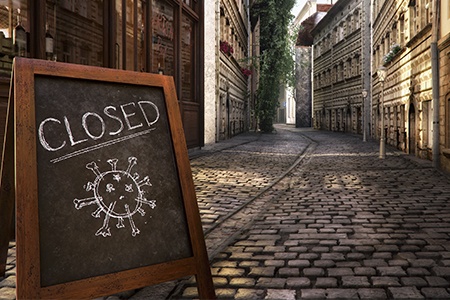 CLOSED message on a blackboard near bar, cafe, shop on an empty street