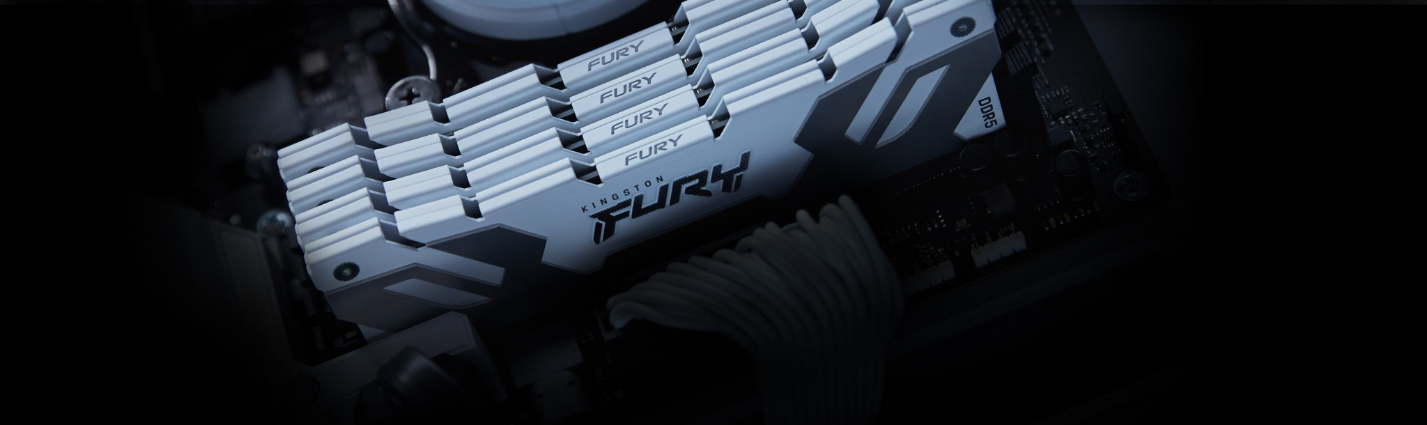 An angled view of four Kingston FURY Renegade DDR5 memory modules, in white, mounted inside a motherboard