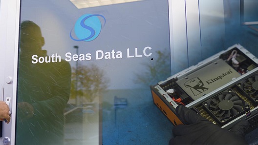 Una puerta con un cartel con el texto "South Seas LLC" y un mini-PC construido con un disco SSD de Kingston instalado