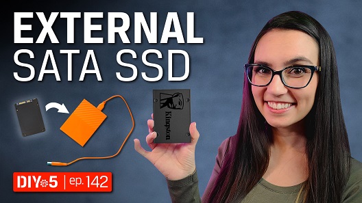 M.2 SSD と microSD カードのそばでゲーム機のコントローラを持つトリシャ。