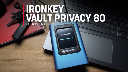 Внешний твердотельный накопитель Kingston IronKey Vault Privacy 80 лежит на ноутбуке, установленном на компьютерном столе.